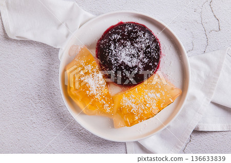 Close up of sweet fruit jelly in coconut flakes on a plate on the table top view 136633839