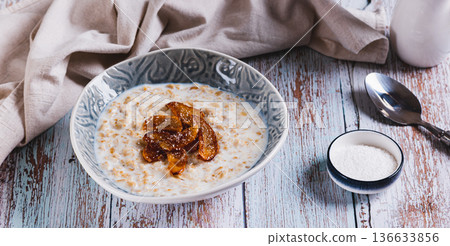 Oatmeal with caramelized apples and coconut flakes in a bowl on the table web banner Oatmeal with caramelized apples and coconut flakes in a bowl on the table web banner 136633856