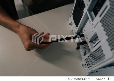 Top view of person hand installing wireless network adapter antenna into personal computer, providing faster internet connection and enhancing data transmission for digital content. 136633912