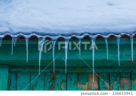 Icicles on the roof of the house. Danger of falling 136633941