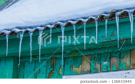 Icicles on the roof of the house. Danger of falling 136633945