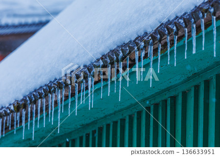 Icicles on the roof of the house. Danger of falling Icicles on the roof of the house. Danger of falling 136633951