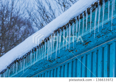 Icicles on the roof of the house. Danger of falling 136633972
