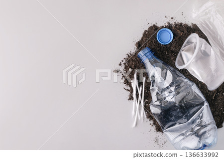 Plastic waste polluting soil with disposable items Plastic waste polluting soil with disposable items 136633992