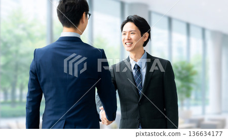 two male businessmen shaking hands 136634177