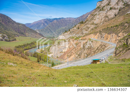 Road stretching along the Chuya River on Chuysky Trakt in Altai Russia. Scenic mountain route through wild Siberian landscape. Road stretching along the Chuya River on Chuysky Trakt in Altai Russia. Scenic mountain route through wild Siberian landscape. 136634307