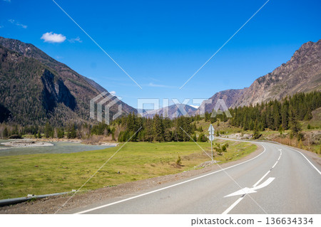 Road stretching along the Chuya River on Chuysky Trakt in Altai Russia. Scenic mountain route through wild Siberian landscape. 136634334
