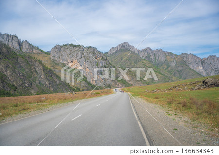 Mountain road running along the Katun river in Altai Russia. Scenic route winding through natural landscapes of the Altai mountains. Mountain road running along the Katun river in Altai Russia. Scenic route winding through natural landscapes of the Altai mountains. 136634343