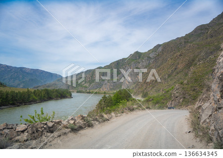 Mountain road running along the Katun river in Altai Russia. Scenic route winding through natural landscapes of the Altai mountains. 136634345
