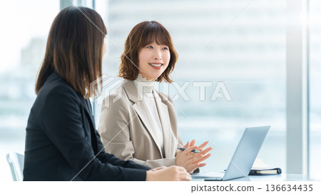 Two women/businesswomen having a meeting Two women/businesswomen having a meeting 136634435