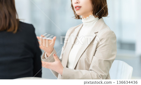 Two women/businesswomen having a meeting Two women/businesswomen having a meeting 136634436