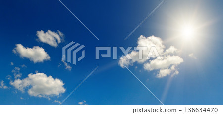 Bright sun shining in a clear blue sky with wispy white clouds Bright sun shining in a clear blue sky with wispy white clouds 136634470