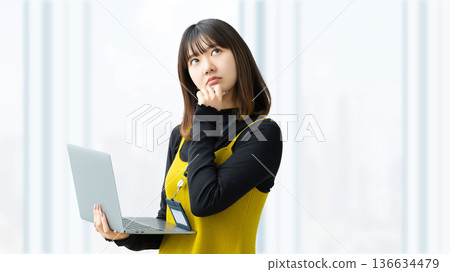 A woman/businesswoman thinking with a laptop A woman/businesswoman thinking with a laptop 136634479