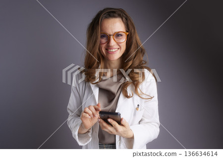 Female Doctor Using Smartphone for Telemedicine Consultation Female Doctor Using Smartphone for Telemedicine Consultation 136634614