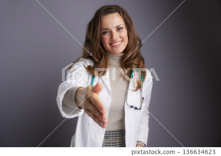 Friendly Female Doctor Offering a Handshake Friendly Female Doctor Offering a Handshake 136634623