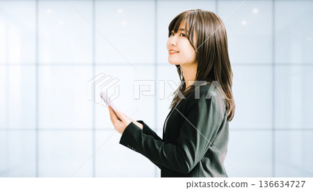 微笑的女人/女商人拿著智慧型手機 136634727