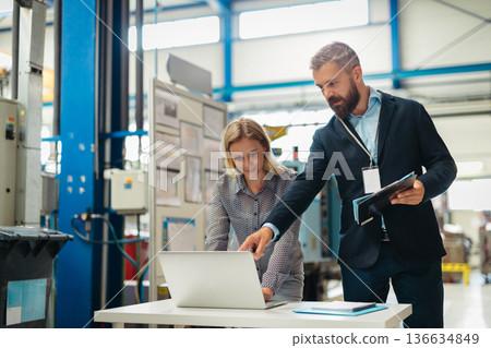 Industrial team analyzing data in high tech manufacturing plant. Industrial team analyzing data in high tech manufacturing plant. 136634849