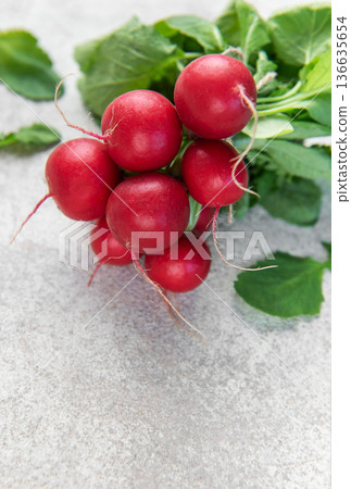 Fresh radishes bunch with green leaves on concrete Fresh radishes bunch with green leaves on concrete 136635654
