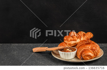 Fresh croissants with chocolate hazelnut spread on plate Fresh croissants with chocolate hazelnut spread on plate 136635716