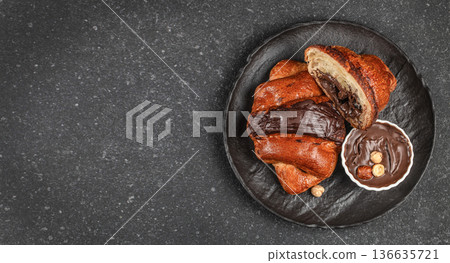 Chocolate filled croissants with creamy hazelnut spread on black plate Chocolate filled croissants with creamy hazelnut spread on black plate 136635721