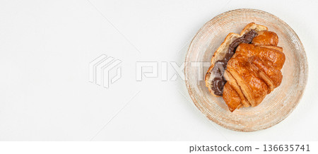 Fresh croissant with chocolate filling on light background Fresh croissant with chocolate filling on light background 136635741