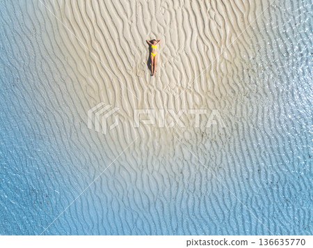 Aerial view of sporty woman in bikini in clear turquoise sea Aerial view of sporty woman in bikini in clear turquoise sea 136635770