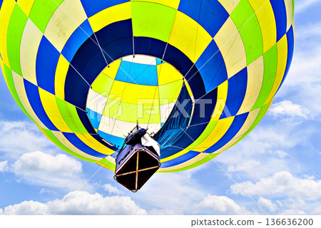 Colorful hot air balloon flying over blue sky with white clouds Colorful hot air balloon flying over blue sky with white clouds 136636200