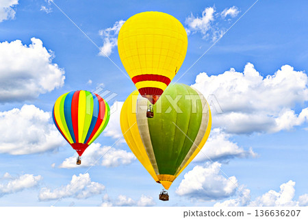 Colorful hot air balloon flying over blue sky with white clouds Colorful hot air balloon flying over blue sky with white clouds 136636207
