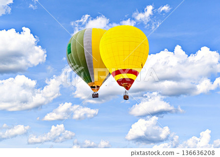 Colorful hot air balloon flying over blue sky with white clouds Colorful hot air balloon flying over blue sky with white clouds 136636208