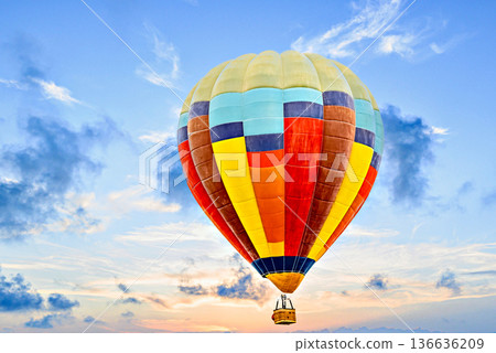 Colorful hot air balloon flying over blue sky with white clouds Colorful hot air balloon flying over blue sky with white clouds 136636209