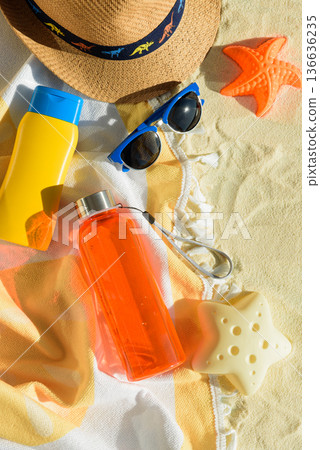 Beach Essentials with Hat, Sunglasses, Sunscreen, Kid Mold and Water Bottle. Summer Vacation Flatlay Beach Essentials with Hat, Sunglasses, Sunscreen, Kid Mold and Water Bottle. Summer Vacation Flatlay 136636235