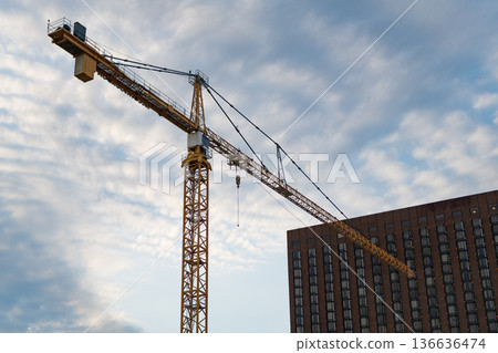 Construction site with building crane. Industrial zone. Building and construction. Hoisting crane. Construction at building site with crane. Construction crane at building area Construction site with building crane. Industrial zone. Building and construction. Hoisting crane. Construction at building site with crane. Construction crane at building area 136636474