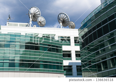 Satellite on building. Architectural design of building. Broadcasting building architecture. Architectural exterior detail. Broadcasting exterior fragment. Modern building with satellite. Satellite on building. Architectural design of building. Broadcasting building architecture. Architectural exterior detail. Broadcasting exterior fragment. Modern building with satellite. 136636518