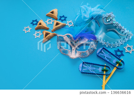 Purim holiday attributes on blue background arranging for celebration Purim holiday attributes on blue background arranging for celebration 136636616