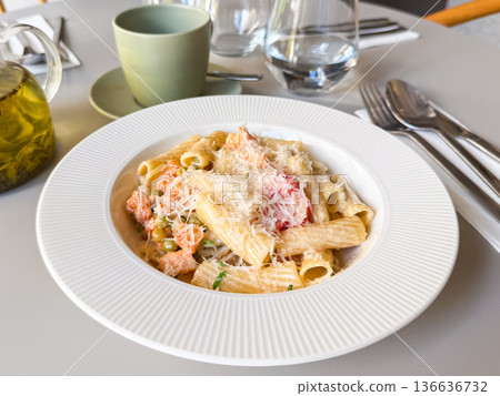 Close-up of pasta with vegetables and grated cheese on white plate. Culinary scene symbolizing gourmet cuisine, nutrition and lifestyle dining. 136636732