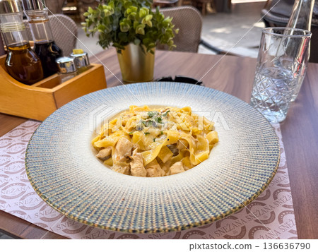Delicious pasta with creamy sauce and chicken. Restaurant cuisine, gourmet dining, and authentic Italian food photography. Delicious pasta with creamy sauce and chicken. Restaurant cuisine, gourmet dining, and authentic Italian food photography. 136636790