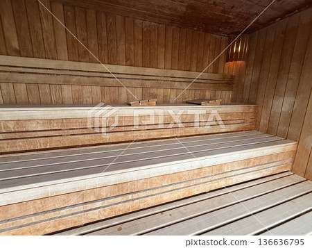 Empty wooden sauna room with tiered benches. Wellness space, heat session, detox ritual, relaxation retreat, hygiene tradition Empty wooden sauna room with tiered benches. Wellness space, heat session, detox ritual, relaxation retreat, hygiene tradition 136636795