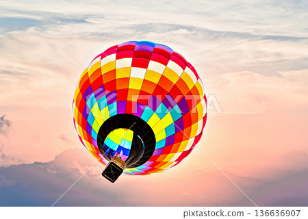 Colorful hot air balloon flying under orange sunset sky Colorful hot air balloon flying under orange sunset sky 136636907