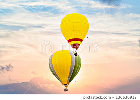Colorful hot air balloon flying under orange sunset sky Colorful hot air balloon flying under orange sunset sky 136636912