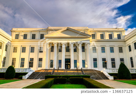Alabama Department of Archives and History in Montgomery, USA. Neoclassical white limestone building features a columned portico and stairs under a blue sky Alabama Department of Archives and History in Montgomery, USA. Neoclassical white limestone building features a columned portico and stairs under a blue sky 136637125