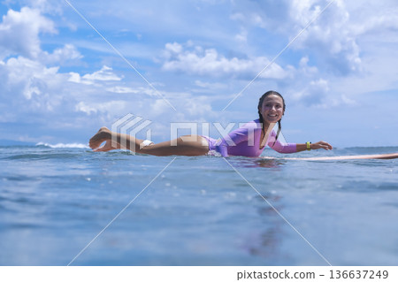 Woman Practicing Accurate Surfing Skills In Peaceful Seaside Environment 136637249