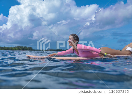 Woman Balances On Ocean Surf, Serene Scene Of Woman Paddling 136637255