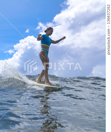 Woman Standing Proudly On Surfboard Amidst Turbulent Cloudy Backdrop Woman Standing Proudly On Surfboard Amidst Turbulent Cloudy Backdrop 136637262