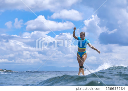 Energetic Female Surfer Demonstrates Control In Dynamic Summer Training Session Energetic Female Surfer Demonstrates Control In Dynamic Summer Training Session 136637284