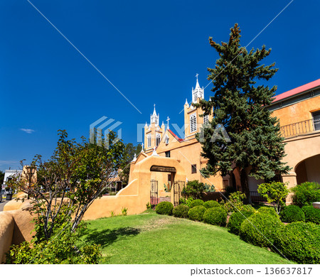 San Felipe de Neri Church in Old Town Albuquerquem New Mexico. Historic adobe Catholic church features twin white towers and a garden under a blue sky San Felipe de Neri Church in Old Town Albuquerquem New Mexico. Historic adobe Catholic church features twin white towers and a garden under a blue sky 136637817