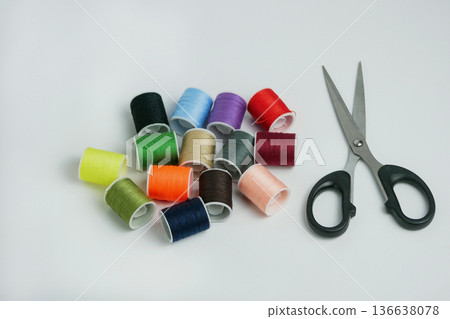 Colorful sewing thread spools with scissors on white background. Tailoring, DIY craft and handmade concept. Studio shot with copy space, high resolution detail 136638078