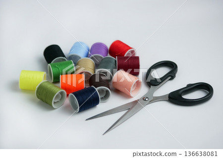 Colorful sewing thread spools with scissors on white background. Tailoring, DIY craft and handmade concept. Studio shot with copy space, high resolution detail 136638081