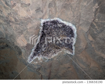 An amethyst geode with white quartz deposits around its perimeter in basalt rock in the ceiling of a tunnel. Wanda mines in Misiones Province, Argentina An amethyst geode with white quartz deposits around its perimeter in basalt rock in the ceiling of a tunnel. Wanda mines in Misiones Province, Argentina 136638190
