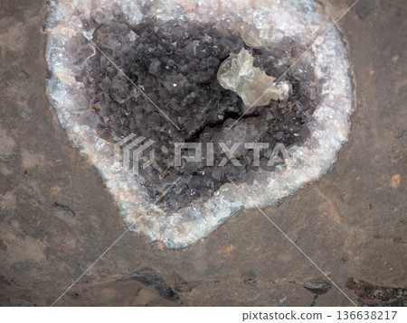 An amethyst geode with purple stones embedded in basalt rock in a tunnel. Wanda mines in Misiones Province, Argentina 136638217