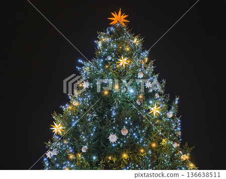 Urban Holiday Display Featuring Luminous Evergreen Adorned With Ornaments And Glowing Star 136638511